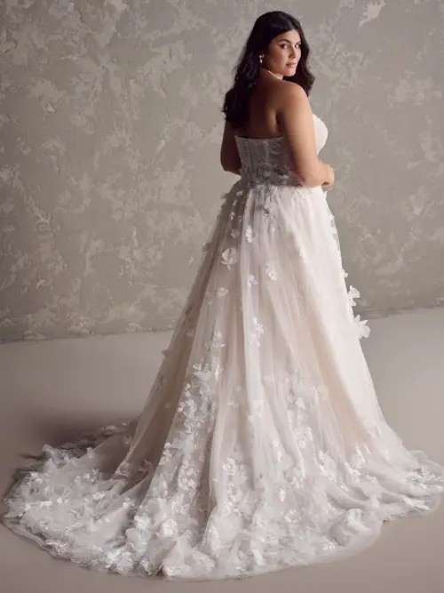 Model is wearing a plus size strapless 3D floral lace wedding dress with a-line silhouette by maggie sottero
